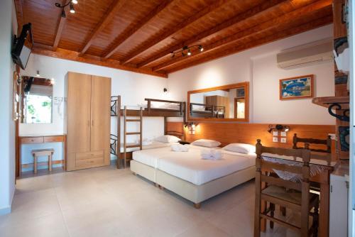 a bedroom with a bed and a desk and bunk beds at Kontaratos Studios & Apartments in Parikia