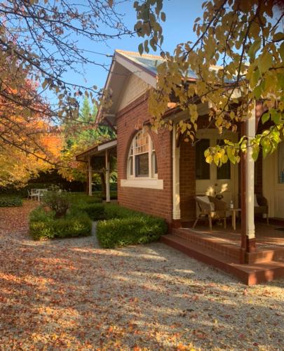 a brick house with a porch and a patio at Howlong Old Post Office Luxury Suite in Howlong