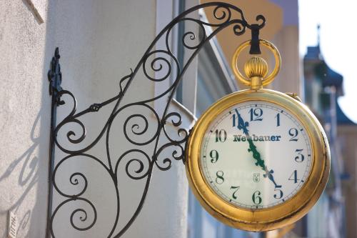 a gold clock hanging on the side of a building at Hotel Landskron in Bruck an der Mur