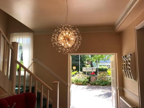 a chandelier hanging in a hallway with a staircase at Hotel Sonneneck in Zinnowitz