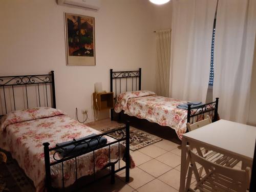 um quarto com duas camas e uma mesa e uma mesa em Locazione Menini - Camere zona stazione em Pádua