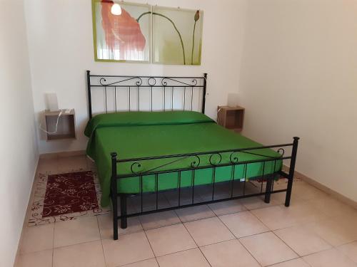 a bedroom with a green bed in a room at Locazione Menini - Camere zona stazione in Padova