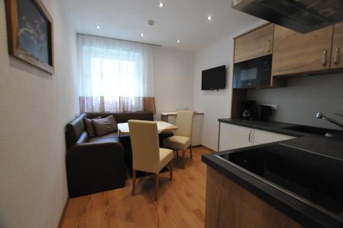 a kitchen and a living room with a couch and a table at Haus Passler in Sankt Jakob in Defereggen