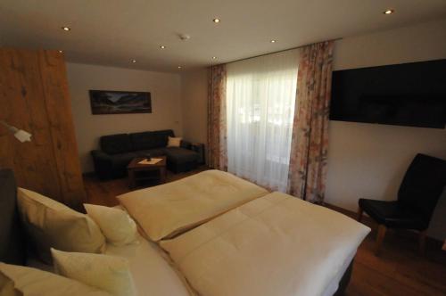 a hotel room with a bed and a couch at Haus Passler in Sankt Jakob in Defereggen