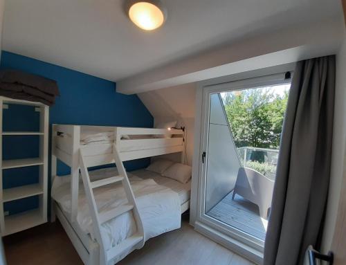 um pequeno quarto com um beliche e uma varanda em Bee Tree Appartement em Vielsalm