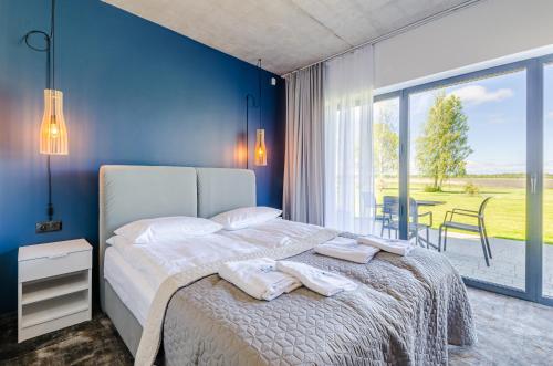 a bedroom with a bed with a blue wall at Kite Marina Sarbsk in Sarbsk