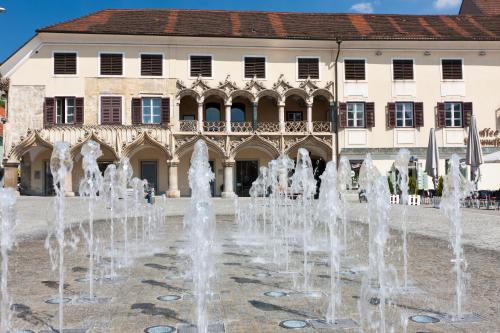 a fountain in front of a building at Hotel Landskron in Bruck an der Mur