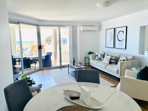 a living room with a table and a couch at Cottesloe Beach View Apartments #7 in Perth