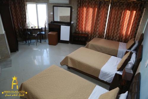 a hotel room with two beds and a mirror at Amman Palace Hotel in Amman
