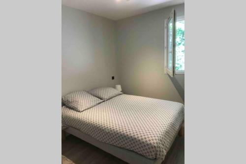 a small bedroom with a bed in the corner at appartement residence avec piscine à anglet limite Biarritz in Anglet