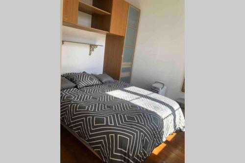 une chambre avec un lit avec une couette noire et blanche dans l'établissement Bel appartement bien placé au cœur de Cannes, à Cannes