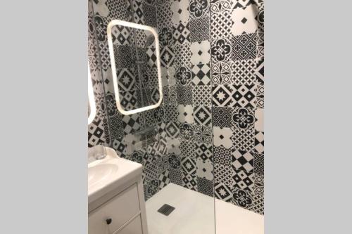 a bathroom with a black and white patterned shower curtain at appartement residence avec piscine à anglet limite Biarritz in Anglet