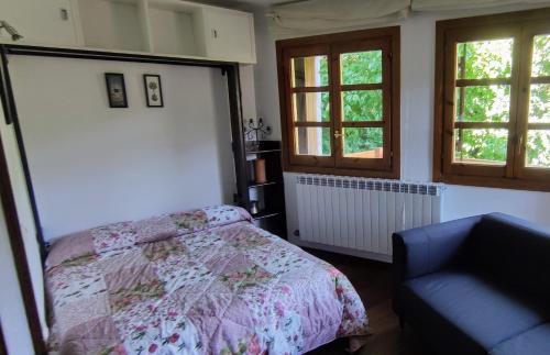 ベナスケにあるLa Solana del Laballのベッドルーム1室(ベッド1台、椅子1脚、窓2つ付)