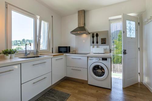a kitchen with a washing machine and a sink at Charming Country House in Ourém