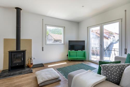 a living room with a fireplace and a tv at Charming Country House in Ourém