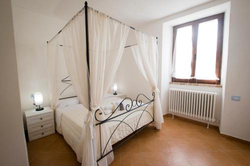 a bedroom with a canopy bed and a window at Il Sasso di San Galgano in Chiusdino