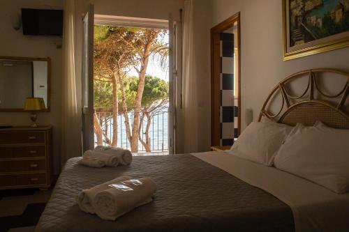 una camera da letto con due asciugamani su un letto con finestra di Villa Sarina ad Acciaroli