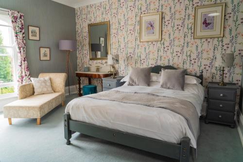 a bedroom with a bed and a chair and a mirror at MonkBridge House in York