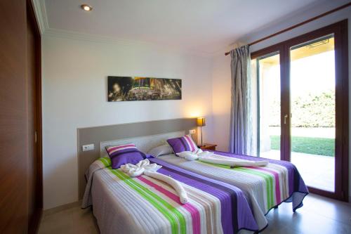een slaapkamer met 2 bedden en een groot raam bij Finca Can Vanrell in Muro