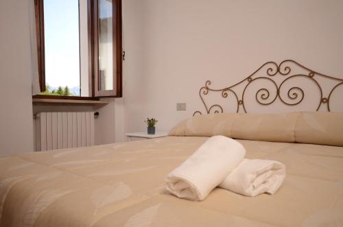 普埃尼亞戈的住宿－Corte Vezzola Trilocale Tommaso，一间卧室配有一张床,上面有两条毛巾