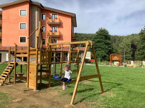 een jong kind speelt op een houten speelplaats bij Arvo Residence Sila in Lorica