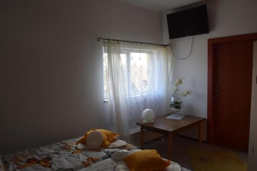 a bedroom with a bed with a window and a table at Apartament Czos in Mrągowo