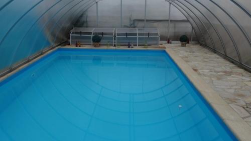 an indoor swimming pool with blue water in a building at Pension und Gästehaus Paffrath in Großbrembach