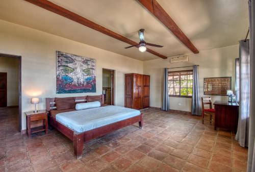 1 dormitorio con 1 cama y ventilador de techo en La Veranera, Playa El Coco en San Juan del Sur