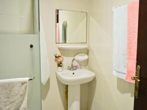 a white bathroom with a sink and a mirror at Amman Palace Hotel in Amman