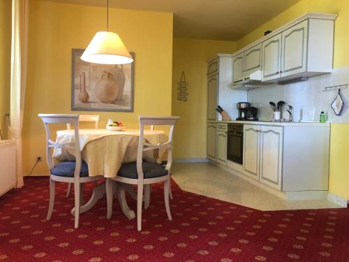 a kitchen with a table and chairs in a room at "Rheinschlosschen" Villa am Meer in Göhren