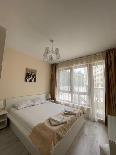 Deluxe Apartment Varna South Bay Beach Residence في مدينة فارنا: غرفة نوم بسرير كبير ونافذة كبيرة