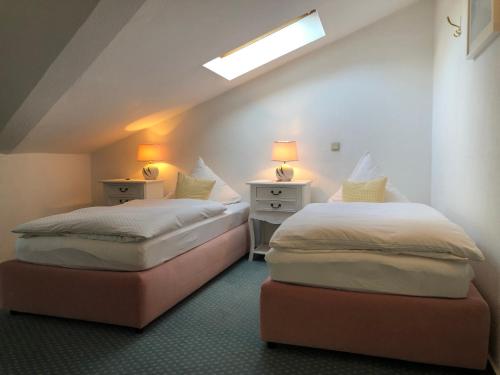 two beds in a room with two lamps on the sides at "Rheinschlosschen" Villa am Meer in Göhren
