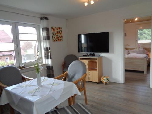 a living room with a table with chairs and a television at Ferienwohnung Simmering in Westerholt