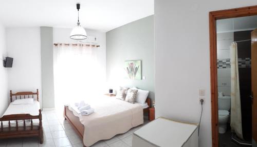 a white bedroom with a bed and a window at Sea&Park View in Skala Marion