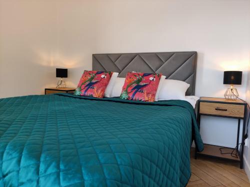 a bedroom with a green bed with two night stands at GOLDEN SANDS in Rowy