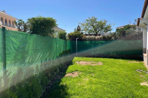 een hek met een groen net bovenop een tuin bij La Juli, Exclusivo chalet nuevo, de lujo in Matalascañas