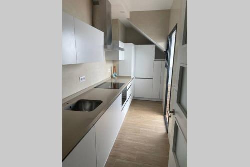 a kitchen with white cabinets and a sink at La Juli, Exclusivo chalet nuevo, de lujo in Matalascañas