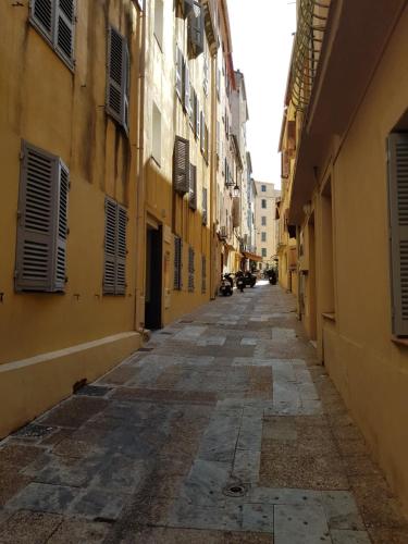 an alley with yellow buildings and an empty street at VIEILLE VILLE D AJACCIO POUR 3 PERs A 300M DU PORT ET A 15 MN DE LAEROPORT PROCHES DE PLUS BELLES PLAGES ET TTES COMMODITES A PROXIMITE in Ajaccio