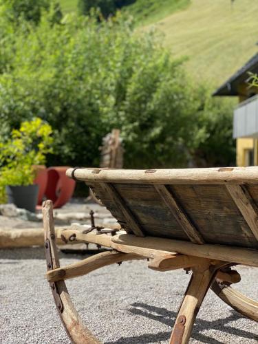 a wooden bench sitting on the side of a yard at Hotel Residenz Hochalm - Joker Card Partner in Saalbach Hinterglemm