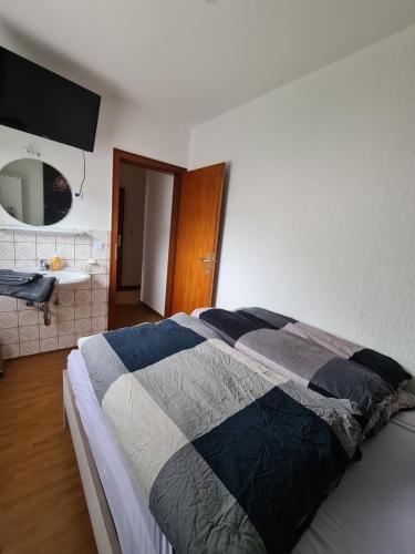 a bedroom with a bed and a bathroom with a sink at Pension Larifari in Drees