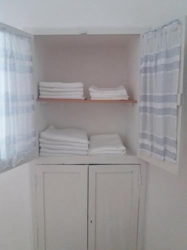 ein Schrank mit weißen Handtüchern auf Regalen und ein Fenster in der Unterkunft Casa Vacanze Mazzini in Santa Maria al Bagno