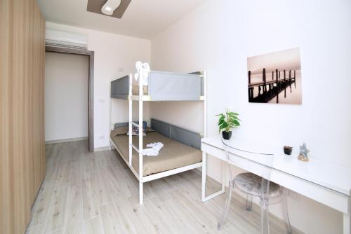 een slaapkamer met een stapelbed en een bureau bij Residenza Oltremare in Peschici