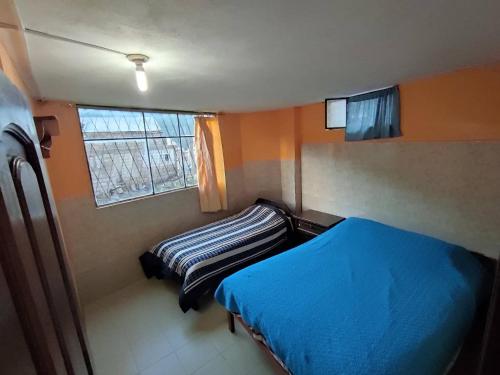 a small bedroom with a bed and a window at Casa Vacacional en Baños de Agua Santa in Baños