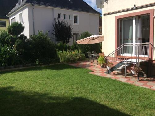 a yard with a patio and an umbrella at URS Ferienwohnung Wertheim in Wertheim