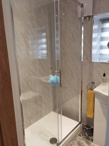 a shower with a glass door in a bathroom at 107 Headwards Retreat in Hemsby