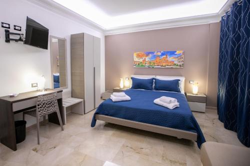 Un dormitorio con una cama azul y un escritorio. en B&B Azul, en Palermo