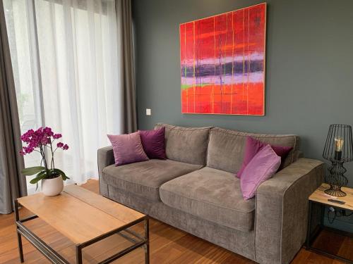 a living room with a gray couch with purple pillows at Le 7 in Vieille-Toulouse