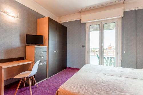 a bedroom with a bed and a desk and a television at Residence & Suites in Bellaria-Igea Marina