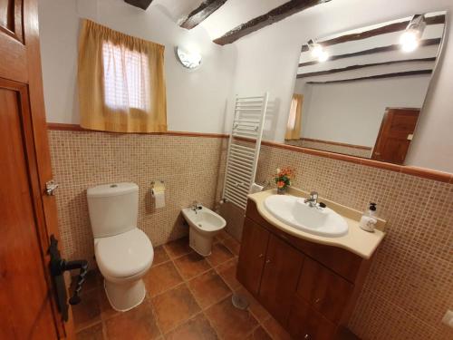 y baño con aseo, lavabo y espejo. en Casa Rural del Pantano 4 Estrellas 