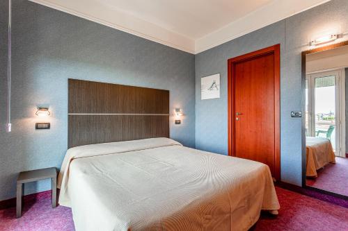 a bedroom with a bed and a wooden door at Residence & Suites in Bellaria-Igea Marina